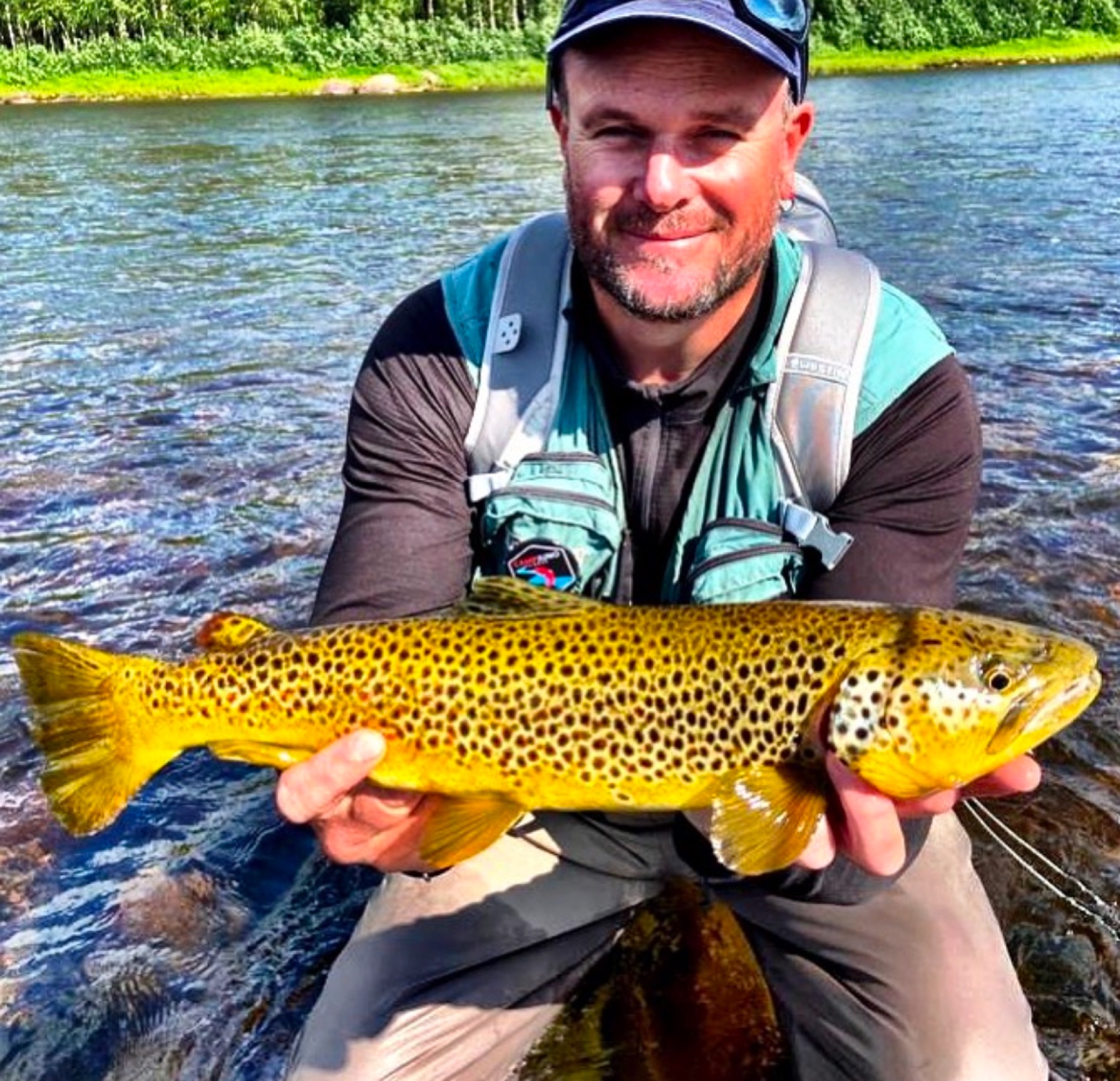 Angler with a trout from a northern river